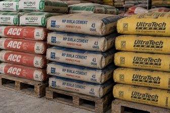 Stacks of Nuvoco, ACC, MP Birla and UltraTech cement bags on wooden pallets