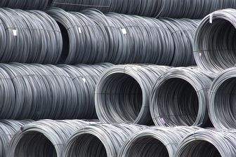 Coils of smooth steel wire rod stacked in rows, some turned end on